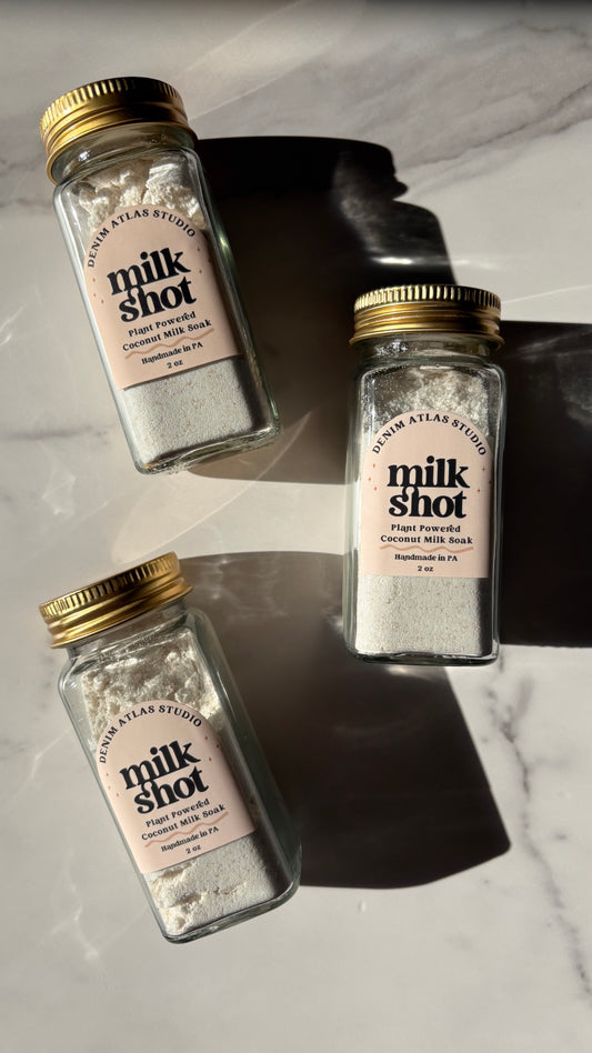 Three bottles of 'milk shot' on a marble surface